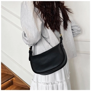 Detail of black lychee grain hobo bag with adjustable strap and gold metal hardware buckle