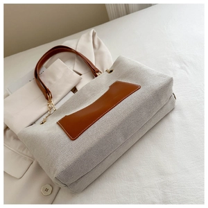 Detailansicht der großen Nylon-Tasche mit braunem Lederbesatz und Kettenriemen