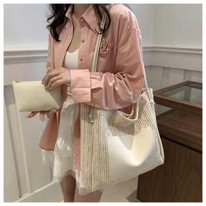 Detail of woven straw tote bag with white leather pocket and matching small zipper pouch
