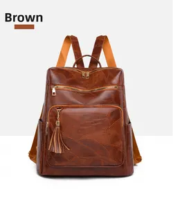 Detailed front view of brown vintage leather backpack with gold zippers and tassels
