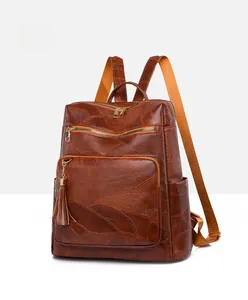 Detail of brown vintage faux leather backpack with leaf vein texture and tassel charm