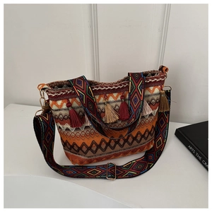 Detail of bohemian straw bucket bag showing woven texture and colorful tassel charms