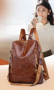 Close-up of vintage brown PU leather backpack featuring water-resistant multi-zipper pockets