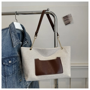 Detail der Nylon-Einkaufstasche mit einer Ledertasche und einem Metallkettenriemen