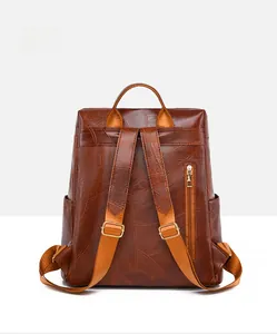 Detail view of the brown leather backpack back with anti-theft zipper and adjustable straps