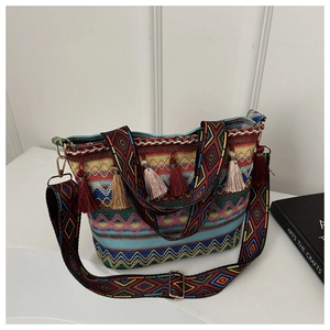 Detail of bohemian woven bag with colorful tassels and embroidered ethnic strap