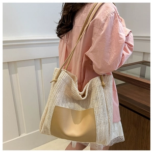 Detailed view of cream straw woven tote bag featuring a brown leather front pocket