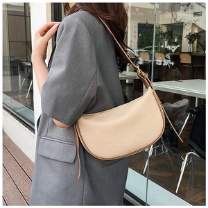 Detail of beige lychee leather hobo bag with dark brown strap on casual blazer