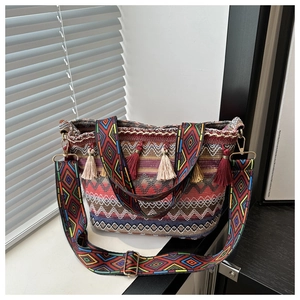 Detail of woven straw bucket bag with colorful ethnic patterns and decorative tassels