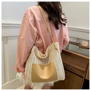 Detail of the woven straw texture and premium khaki leather pocket on the tote bag