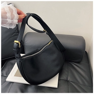 Detail of black lychee grain leather dumpling bag with gold buckle and adjustable strap