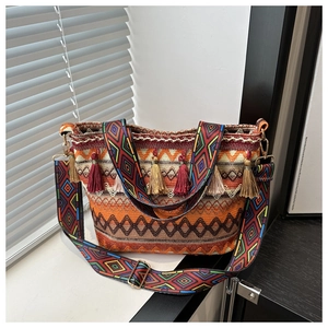 Detail of colorful geometric woven pattern and tassel trim on ethnic bucket bag