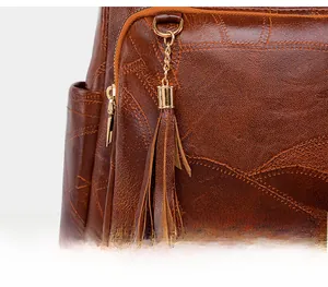 Detail shot of brown vintage leather backpack showing lychee texture and long tassels