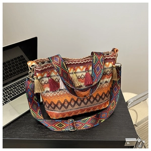 Close-up of bohemian woven bucket bag featuring colorful geometric patterns and tassels
