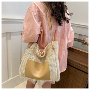 Detail of beige straw tote bag with faux leather pocket and drawstring shoulder strap