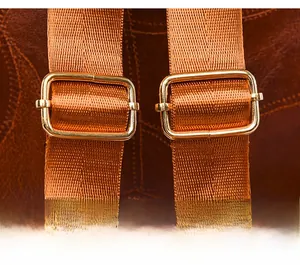 Detail view of adjustable high-density nylon straps with golden metal buckles on brown backpack