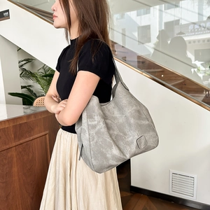 Detail of grey washed leather tote bag showing vintage texture and spacious compartments