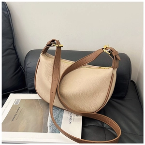 Detailed macro view of beige lychee leather half-moon hobo bag with brown edge oil