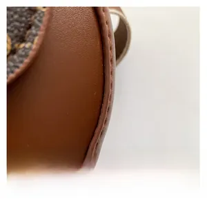 Nahaufnahme der braunen Leder-Satteltasche mit präzisen Nähten und gemustertem Canvas