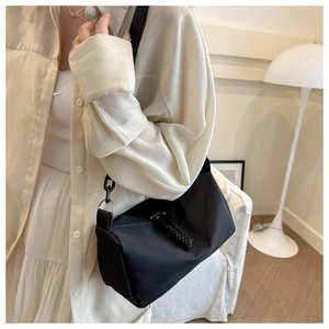 Close-up of black nylon shoulder bag with silver zipper and chain strap detail