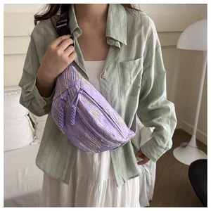 Détail du sac bandoulière en toile violette avec broderies et sangle réglable