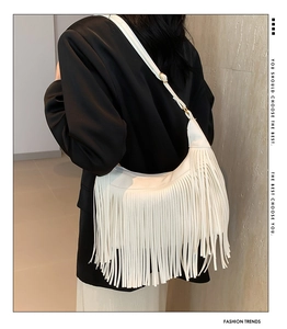 Gros plan du sac à bandoulière bohème blanc avec franges denses et forme de croissant