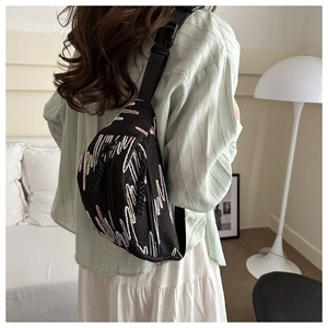 Détail du sac bandoulière noir matelassé avec broderie vagues et sangle réglable