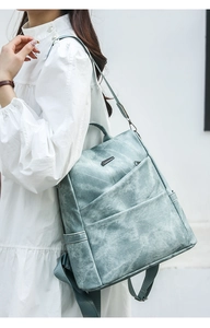 Soft faux leather blue backpack featuring geometric metal detail and side water bottle pocket