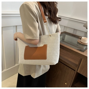 Detailansicht der großen Canvas-Tasche mit brauner Ledertasche und goldener Kette