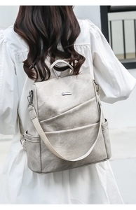 Detailed back view of a minimalist grey soft leather backpack with adjustable straps