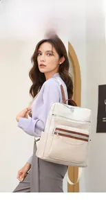Detail of embossed leaf texture on beige PU leather backpack with brown zipper accents