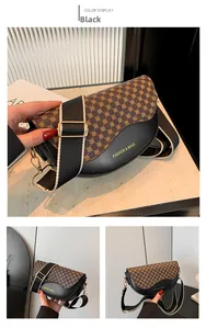 Detail der schwarzen Satteltasche mit geometrischem Print und breitem Schultergurt