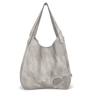 Close-up of grey canvas tote bag with vintage washed texture and leather patch detail