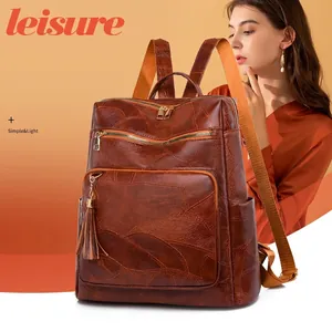 Large vintage brown faux leather backpack with tassels and orange straps for travel