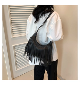 Gros plan d'un sac bandoulière en similicuir noir orné de longues franges tendance