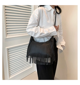 Vue détaillée d'un sac à bandoulière en denim noir avec de longues franges