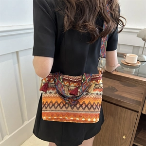 Ethnic straw bucket bag with colorful geometric patterns and decorative tassels
