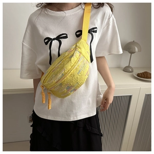 Détail du sac bandoulière jaune vif avec broderie et tissu texturé particulier