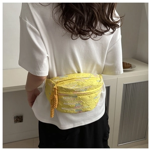 Détail du sac à bandoulière jaune avec motif gaufré et coutures colorées élégantes