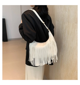 Détail du sac à bandoulière en denim crème avec franges lisses et bandoulière réglable