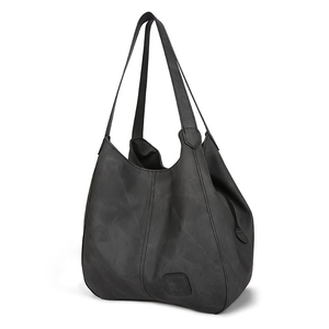 Close-up of a black tote bag with distressed matte finish and subtle embossed logo detail