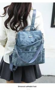 Detail of dark blue faux leather backpack with matte texture and silver geometric accents