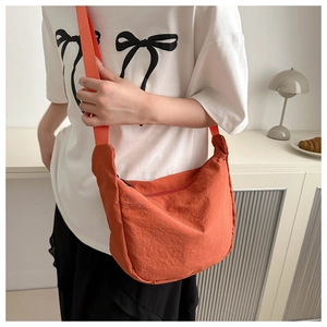 Detail einer leuchtend orangefarbenen Oxford-Umhängetasche mit verstellbarem Riemen