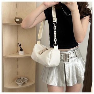 Detailed shot of white nylon crossbody bag with stylish acrylic chain strap and wide strap