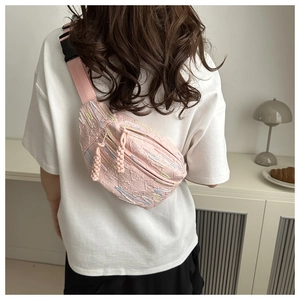 Sac bandoulière rose matelassé avec broderie porté par une fille dans un décor décontracté