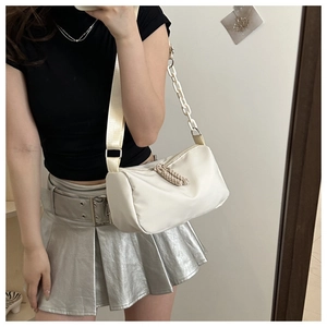 Beige nylon shoulder bag detail showing adjustable wide strap and resin chain link