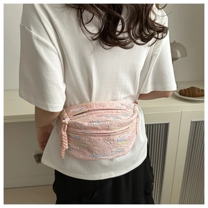 Détail d'un sac bandoulière en jacquard rose avec broderie et tirette tissée