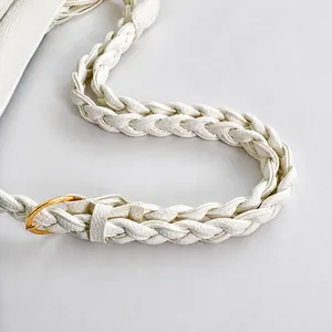 Detail of white lychee grain leather strap with gold ring buckle and fine stitching