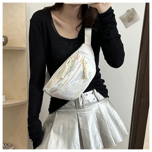 Détail d'un sac bandoulière blanc avec broderie rayée colorée et fermetures à cordon
