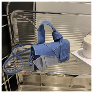 Denim patchwork crossbody tote bag with knot flap design and contrast stitching details